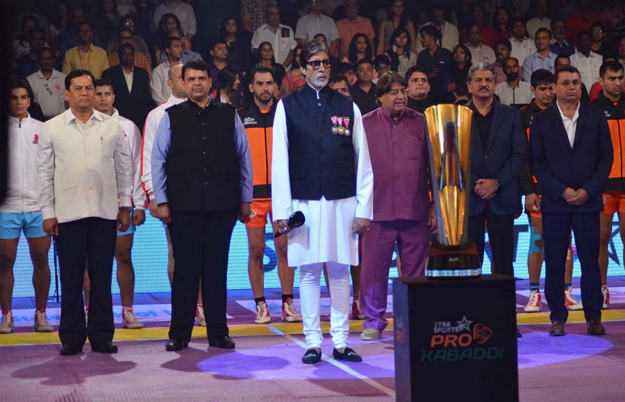 Amitabh Bachchan stands ahead of Maharashtra Chief Minister Devendra Fadnavis, Anand Mahindra, CMD, Mahindra Group, and Uday Shankar, CEO, Star TV, as he prepares to sing the Indian national anthem during the inaugural match after the opening ceremony of the Pro Kabaddi League 2015